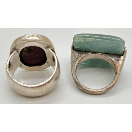 1111 - 2 modern design silver rings. One bezel set with a large oval cut purple natural stone the other wit... 