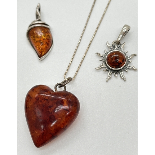 1112 - 3 amber pendants. A heart shaped cognac amber pendant on an 18