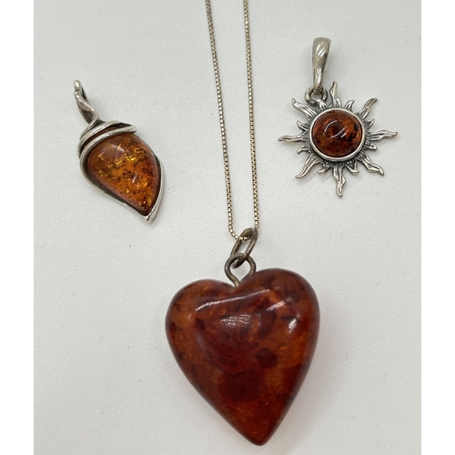 1112 - 3 amber pendants. A heart shaped cognac amber pendant on an 18