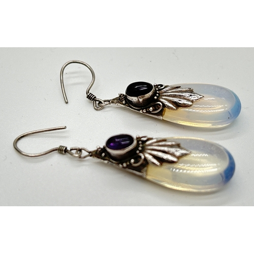 1124 - A pair of silver, moonstone and amethyst drop style earrings with silver scallop and scroll design o... 