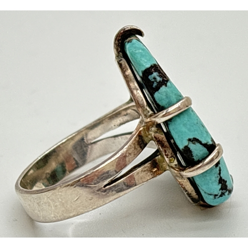 1136 - A modern design silver dress ring, claw set with a large oval cut blue turquoise stone. Silver marks... 