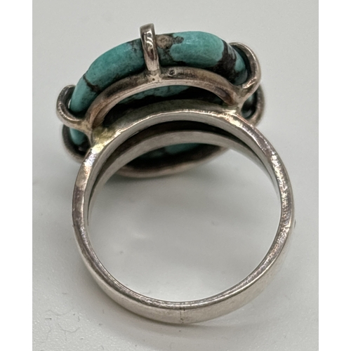 1136 - A modern design silver dress ring, claw set with a large oval cut blue turquoise stone. Silver marks... 