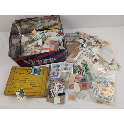 87 - A tin containing a quantity of loose vintage British and foreign stamps. To include sovereign heads ... 