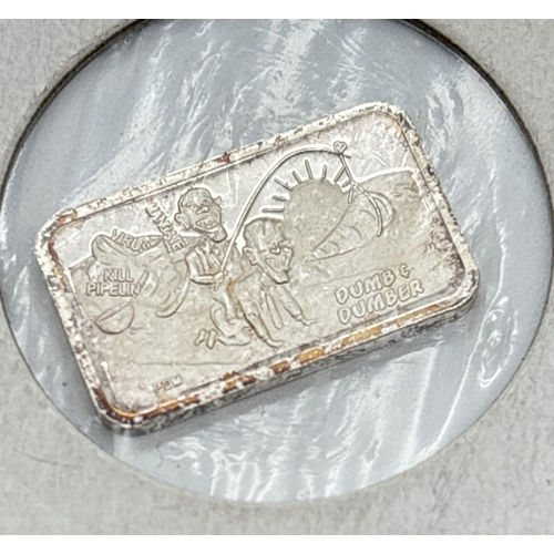 21 - 2 American novelty 999 fine silver 1/10th oz bullion bars. One bar detailed with characters from Dum... 