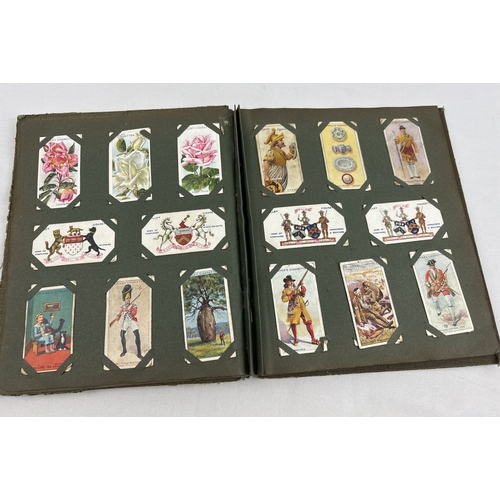 112 - A early 20th century cigarette card album containing a quantity of assorted cards to include Smith's... 