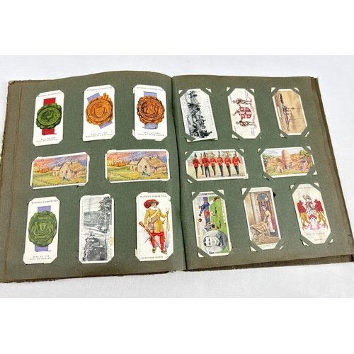 112 - A early 20th century cigarette card album containing a quantity of assorted cards to include Smith's... 