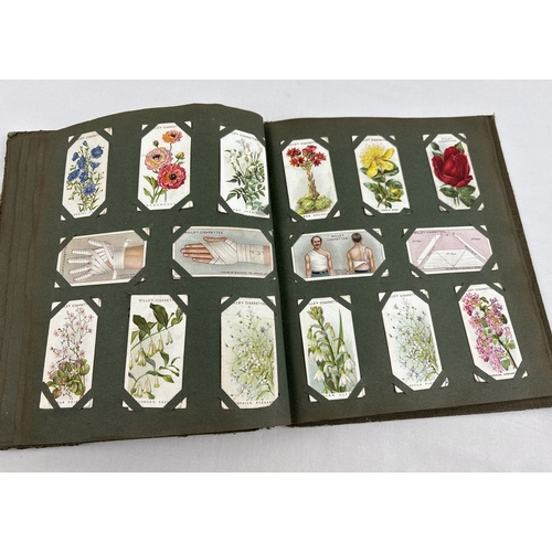 112 - A early 20th century cigarette card album containing a quantity of assorted cards to include Smith's... 