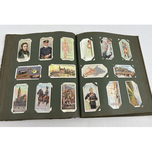 112 - A early 20th century cigarette card album containing a quantity of assorted cards to include Smith's... 