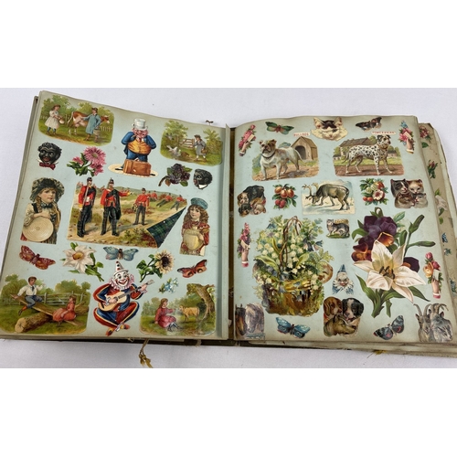 A Victorian scrap album containing a large quantity of assorted greeting cards and scraps. Pages heavily covered with scraps to include animals, flowers, ethnic characters, firemen, ships, soldiers and fruit. Cover of album is loose and damage to spine.