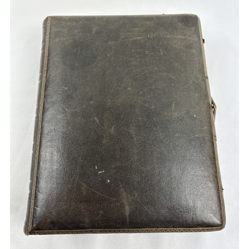 182 - A Victorian leather bound photograph album with metal clasp, containing assorted portrait cabinet ca... 