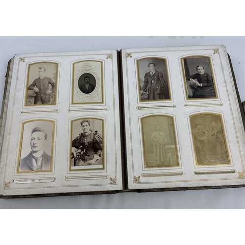 182 - A Victorian leather bound photograph album with metal clasp, containing assorted portrait cabinet ca... 