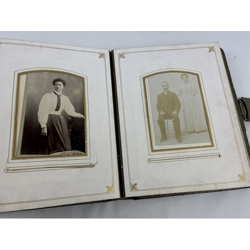 182 - A Victorian leather bound photograph album with metal clasp, containing assorted portrait cabinet ca... 