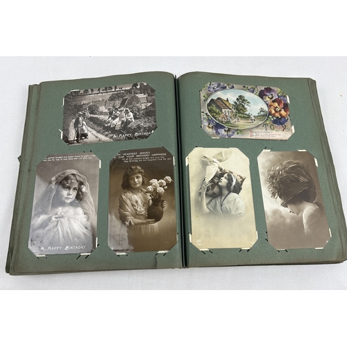 259 - An early 20th century postcard album containing 330 assorted greetings cards and British postcards, ... 