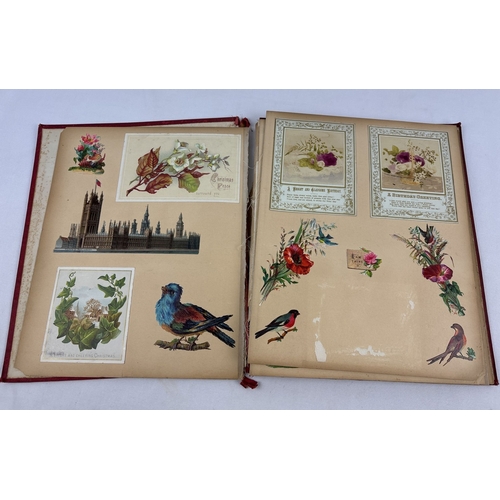 214 - A Victorian scrap book, red cloth bound cover with gilt detail, dated 1883 - damage to spine, covers... 