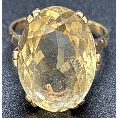 1113 - A 9ct gold large oval cut pale yellow citrine cocktail ring. Double prong set in a raised mount with... 