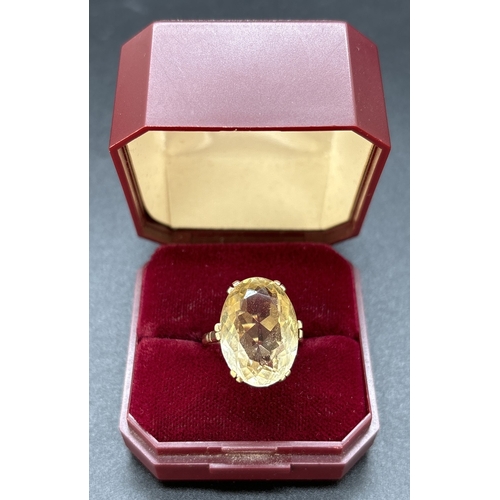 1113 - A 9ct gold large oval cut pale yellow citrine cocktail ring. Double prong set in a raised mount with... 