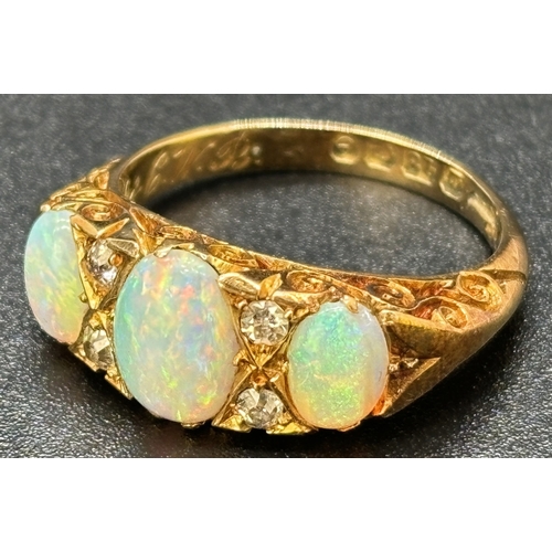 1114 - An Edwardian 18ct yellow gold opal and diamond ring. 3 oval cut opals and 4 small round cut diamonds... 