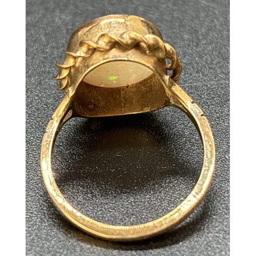 1117 - A vintage 9ct gold large oval cut bezel set opal dress ring with twist design surround. Split should... 