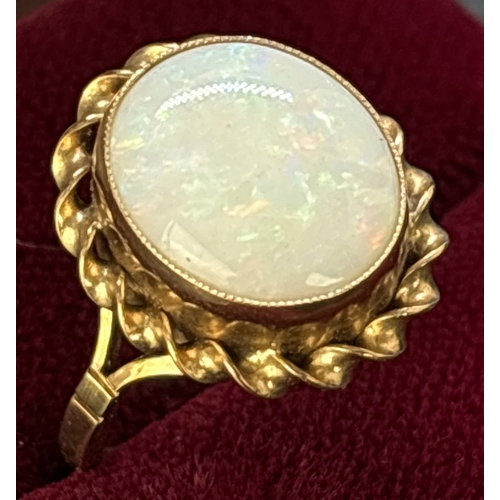 1117 - A vintage 9ct gold large oval cut bezel set opal dress ring with twist design surround. Split should... 