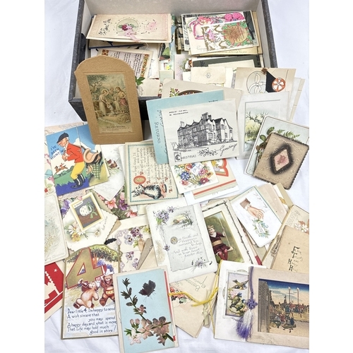 235 - A box containing 295 assorted early to mid 20th century greetings cards, in varying styles and sizes... 