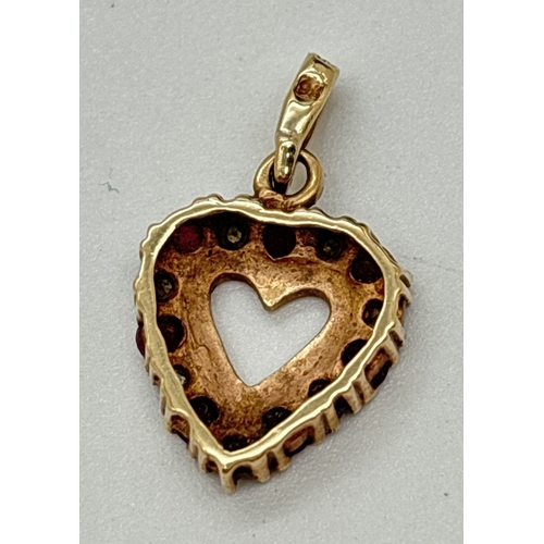 1017 - A 9ct gold heart shaped pendant set with alternating rubies and diamonds. Gold marks to back of bale... 