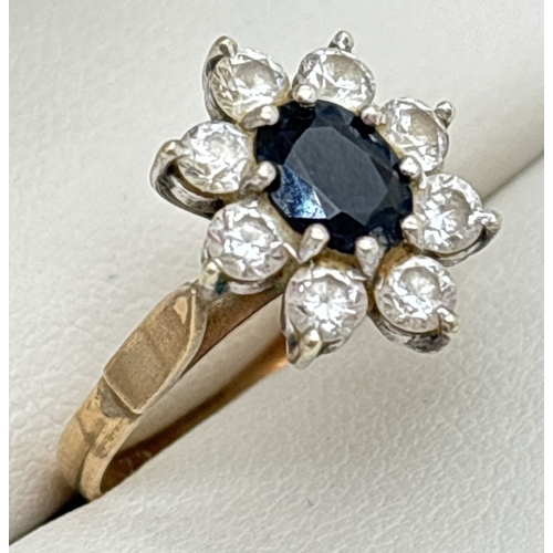 1042 - A vintage 9ct gold sapphire and clear stone cluster style ring. Central oval cut sapphire surrounded... 