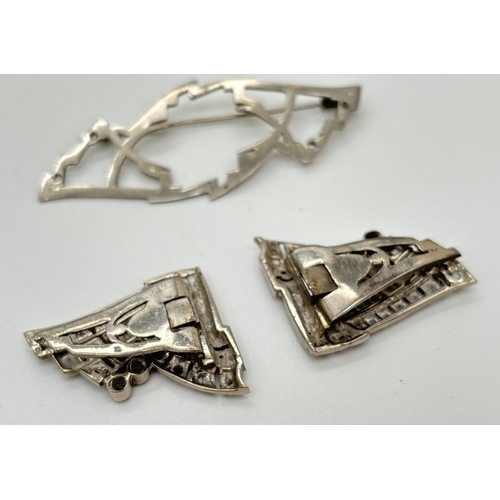 1044 - An art Deco French silver brooch/dress clip in the shape of a bow, set with multiple round cut clear... 