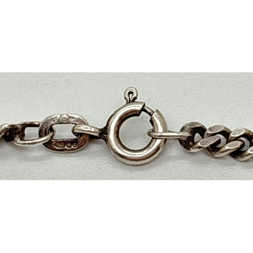 1057 - A 24 inch silver curb chain necklace with spring ring clasp. Silver marks to clasp and fixings. Tota... 