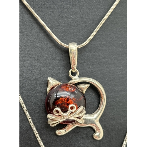 1062 - 2 amber set pendant necklaces. A white metal cat pendant set with cognac amber, on a silver 16