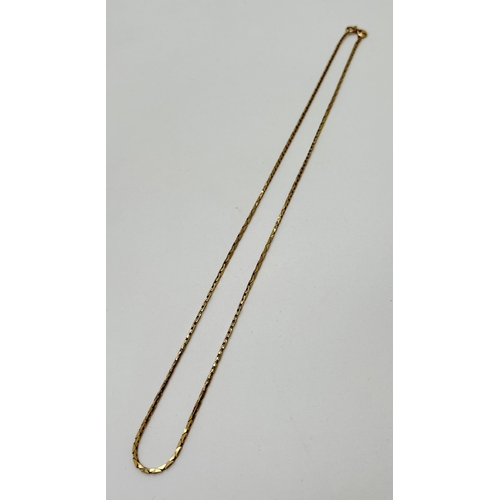 1063 - A 9ct gold 18 inch triangular flat link chain necklace with spring ring clasp. Gold marks to clasp a... 