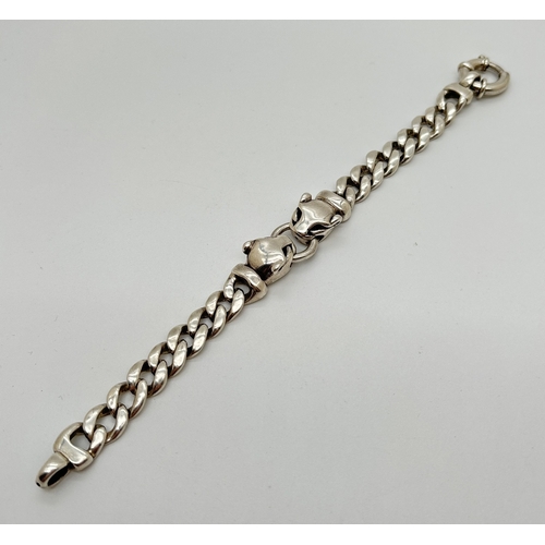 1002 - A 7.5 inch silver curb chain bracelet with 2 Leopards head links. Large spring clasp fastening. Silv... 