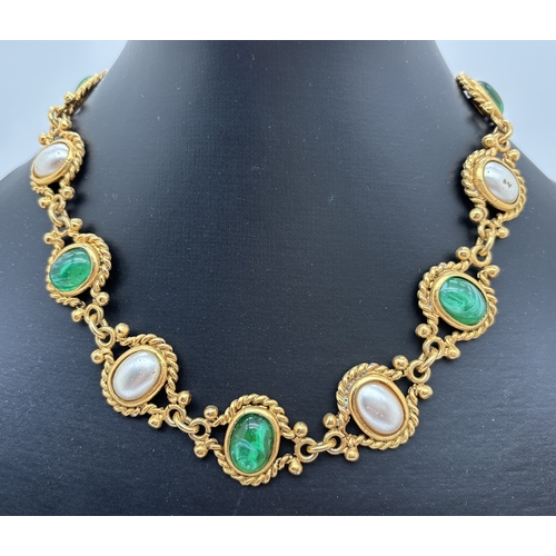 A vintage 17 inch oval link gold tone necklace by Pinky, Paris. Alternating bezel set links of faux pearl and green glass cabochons with rope detail to each link. Small panel to back of each link with Pinky Paris name. T bar clasp with floral decoration to ring.