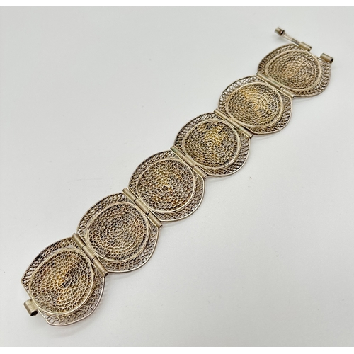 1070 - A vintage White metal filigree 6 panel bracelet decorated with Egyptian characters and scenes. Push ... 