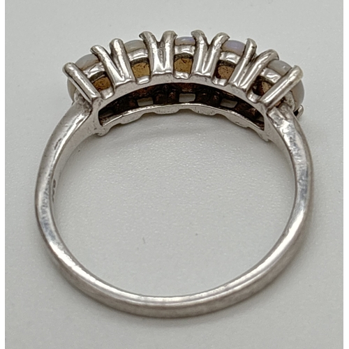 1072 - A silver half eternity style ring set with 5 oval cut white opals. Silver marks to inside of band. S... 