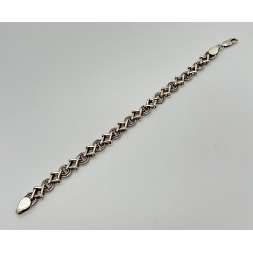 1073 - A 7.5 inch modern design Hugs & Kisses style bracelet with lobster claw clasp. Silver marks to fixin... 