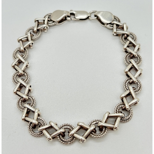 1073 - A 7.5 inch modern design Hugs & Kisses style bracelet with lobster claw clasp. Silver marks to fixin... 