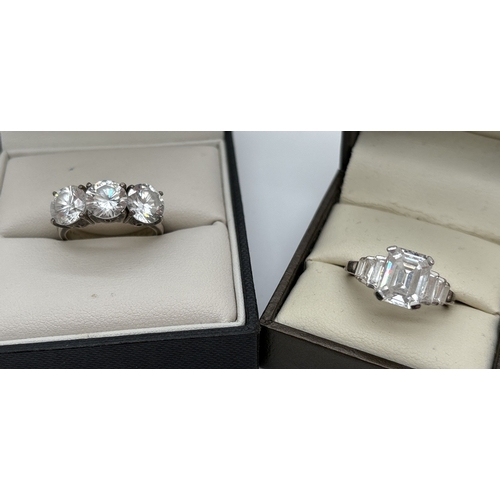 1075 - 2 silver cocktail rings both set with clear stones. A trilogy style ring set with 3 large round cut ... 