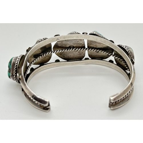 1082 - A Native American silver cuff bangle set with 5 pieces of natural blue turquoise with rope detail to... 