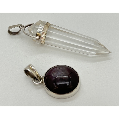 1098 - 2 small natural stone pendants. A circular shaped ruby cabochon pendant in a silver mount, together ... 