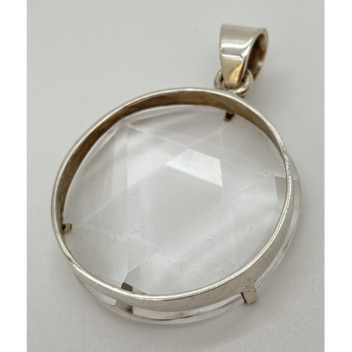 1099 - A large circular 6 pointed star polished clear quartz pendant with silver mount and bale. Silver mar... 