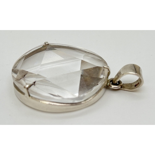 1099 - A large circular 6 pointed star polished clear quartz pendant with silver mount and bale. Silver mar... 