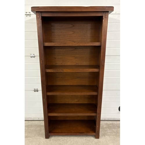 1462 - A large mango wood 'Zocalo' fixed shelf bookcase with panelled wood and peg design. Approx. 184cm ta... 