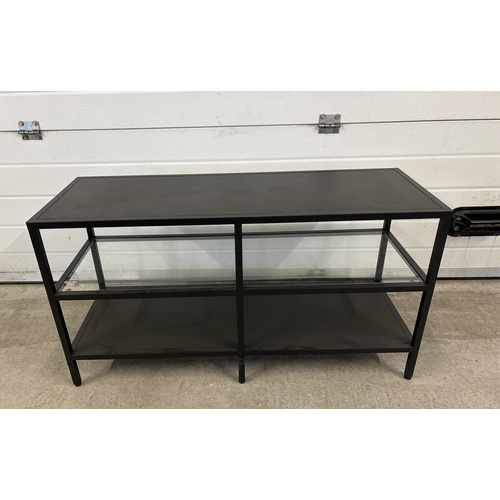 1467 - A modern black metal low shelving unit with glass shelf. Approx. 53.5cm tall x 100cm long.