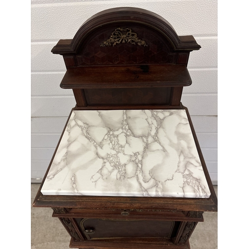 1469 - An antique French nightstand with marble lined pot cupboard and ornate bronzed metal moldings. With ... 