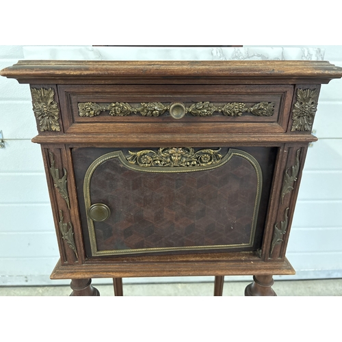 1469 - An antique French nightstand with marble lined pot cupboard and ornate bronzed metal moldings. With ... 