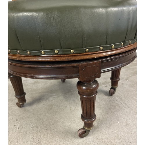 1472 - An antique swivel captains chair with green leather upholstery back, arms and seat. With turned spin... 