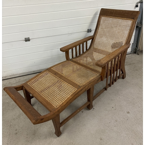 1476 - A vintage colonial style wooden framed lounger with woven cane seat. Approx. 180cm long.