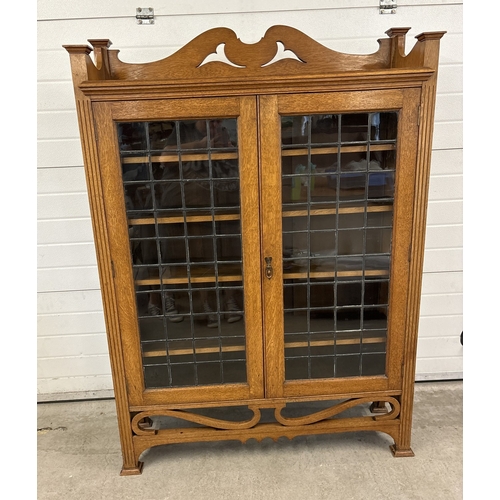 1479 - An early 20th century Art Deco light oak double bookcase with leaded glass doors and carved detail. ... 