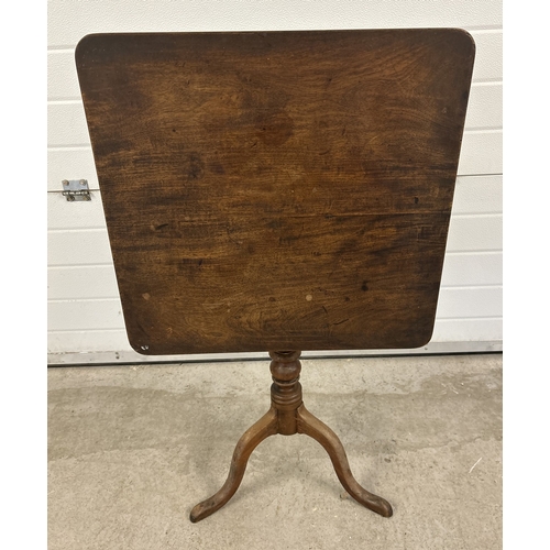 1485 - An antique walnut tilt top table with turned pedestal column and raised on tripod feet. Square shape... 