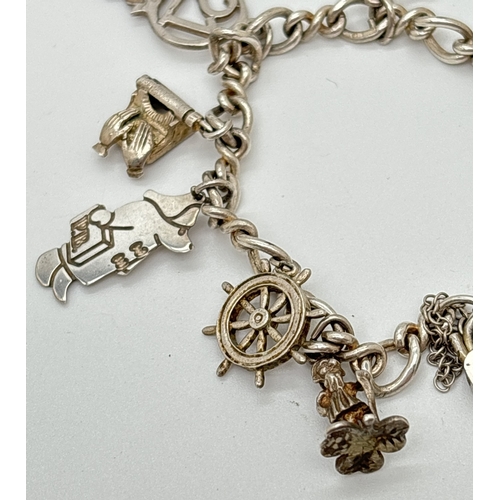 1105 - A vintage silver charm bracelet with 9 assorted silver & white metal charms and heart shaped padlock... 